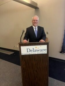 family law attorney Carl Heckert stands at a podium market delaware historical society